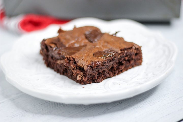 closeup of a chewy fudge brownie from scratch on a white plate
