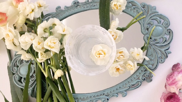 Learn how to prevent a simple floral arrangement from looking cheap in this tutorial for a floral arrangement with pink peonies on a mirror centerpiece. 