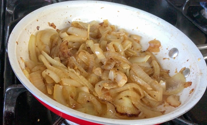 Sliced onions caramelized with beer in white bowl