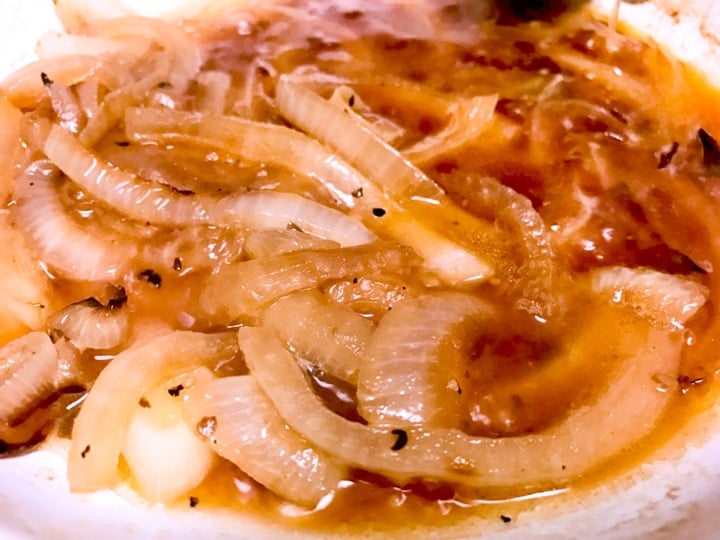 Sliced onions caramelized with beer on white plate