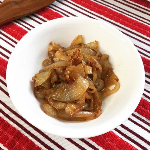 Sliced onions caramelized with beer in white bowl