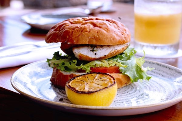 Chef's Table Maui Tropical Plantation Restaurant fish sandwich comes with macadamia nut pesto, tomato, frisée, and shallot