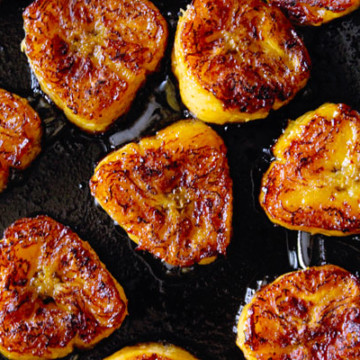 roasting fried sweet plantain slices in a pan