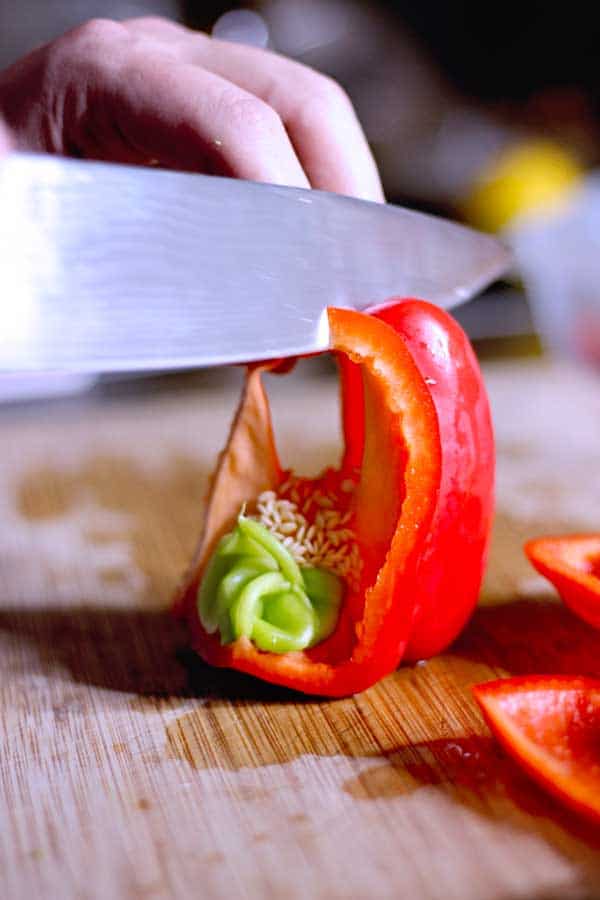 Cutting A RED PEPPER into strips upside down on a cutting board