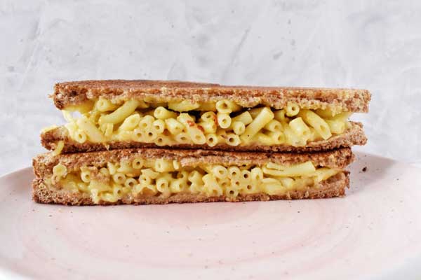 vegan grilled cheese with mac and cheese on a white plate
