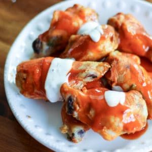 crispy sous vide chicken wings with buffalo sauce with bleu cheese dressing on a white plate