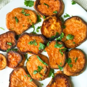 savory roasted sweet potatoes with blue cheese crumbles on a white plate