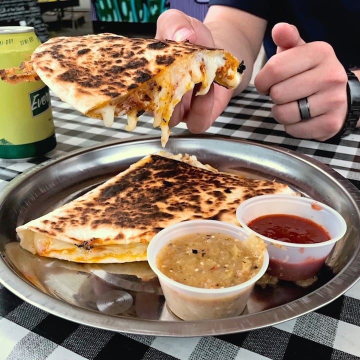 holding up MF Tasty food cart's quesadilla with pork and pineapple