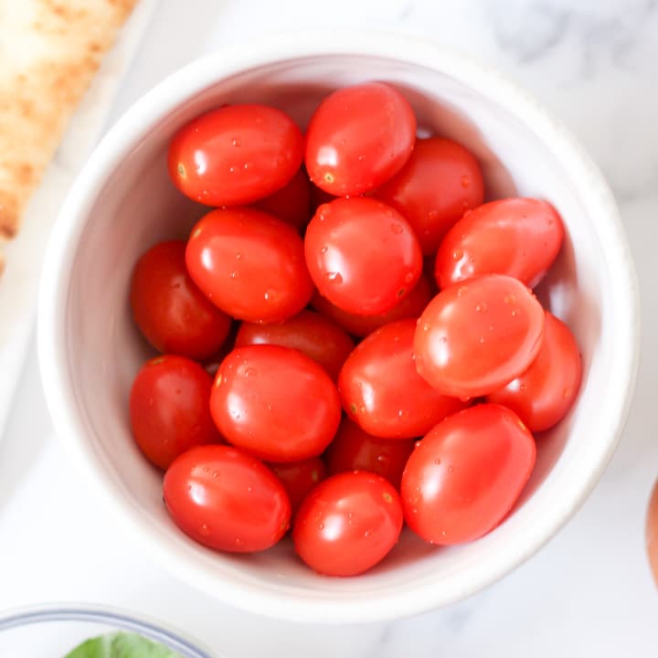 fresh raw cherry tomatoes in a white bowl