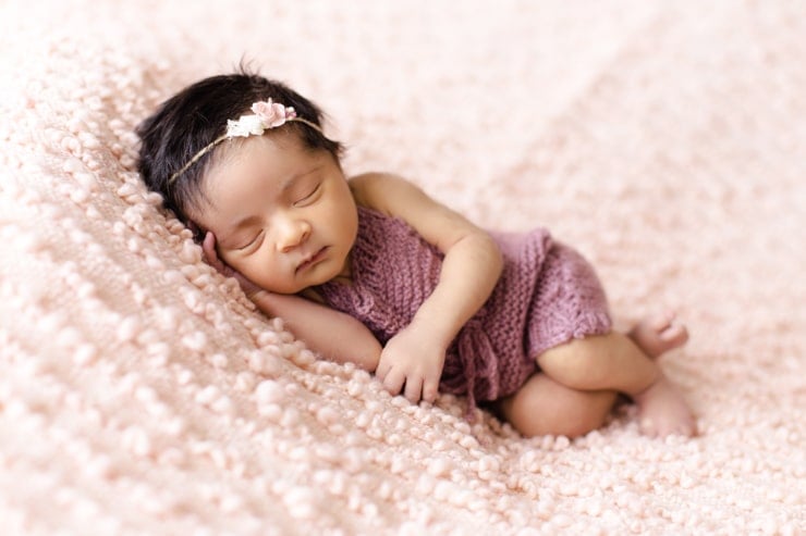 Baby sleeping in a sleeveless onesie