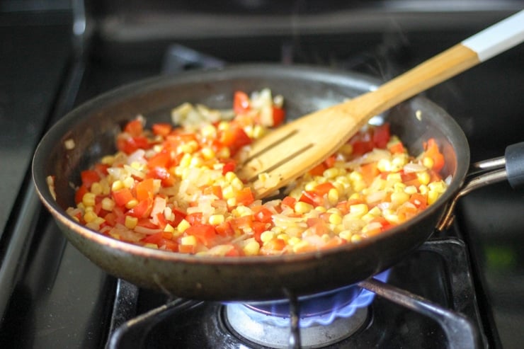 diced red pepper, onion and corn in a large pan