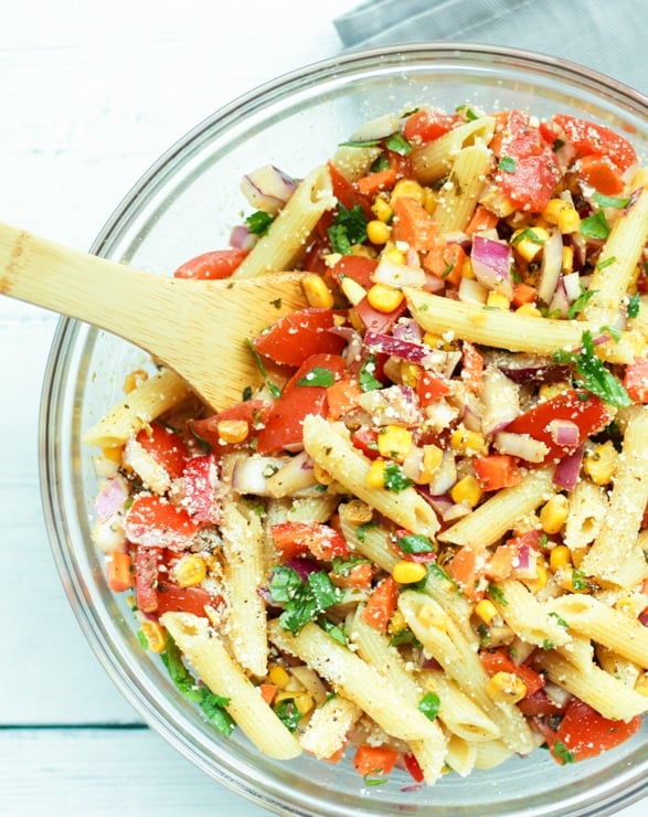make ahead Mexican pasta salad with chili lime dressing in a serving bowl with wooden spoon