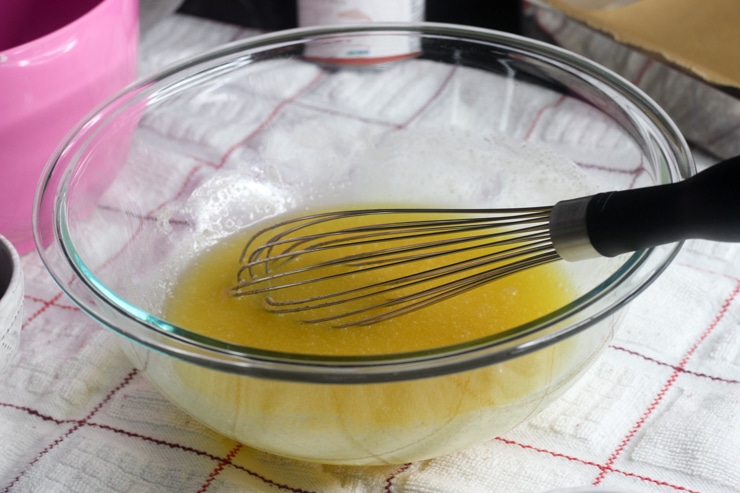 mixing bowl with melted butter and sugar and a whisk