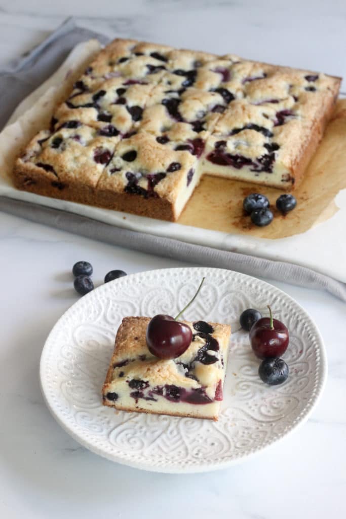 these fresh blueberry and cherry cake bars on a table
