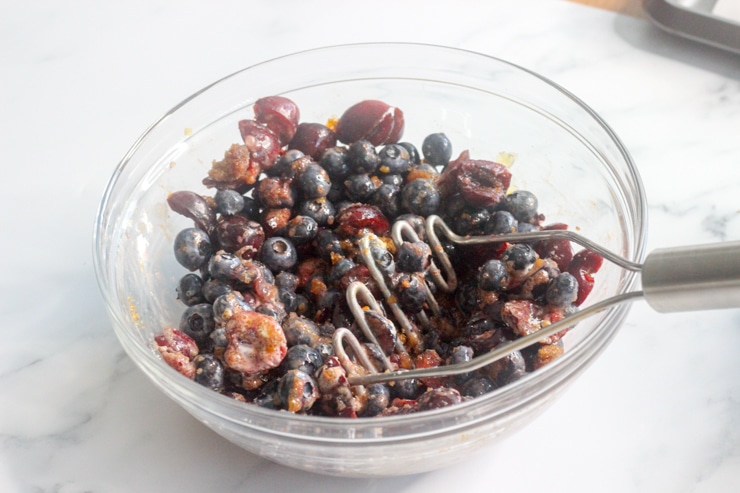 large mixing bowl with cherries, blueberries, brown sugar and berry galette ingredients
