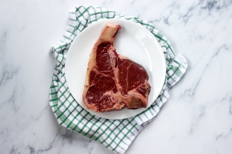raw t bone steak on a kitchen towel