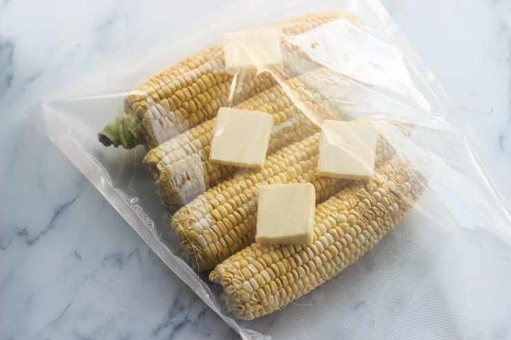 preparing sous vide corn on the cob with butter and salt