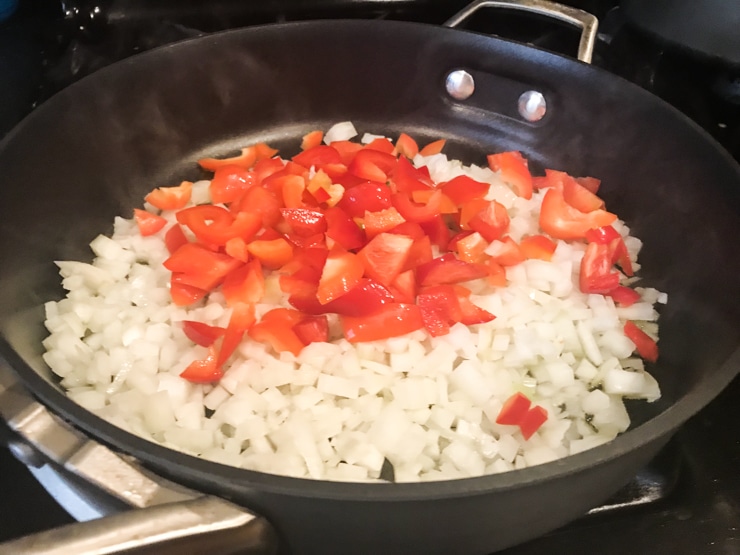 sautéing red pepper and onion and olive oil in a pan 