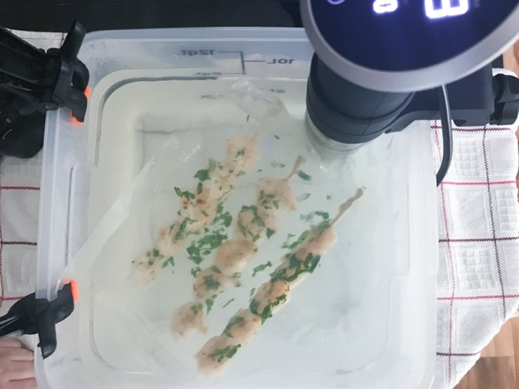 vacuum sealed shrimp in a sous vide bath