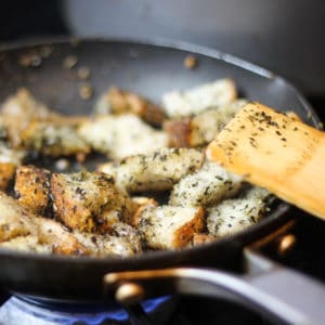 demonstrating homemade italian croutons on the stove