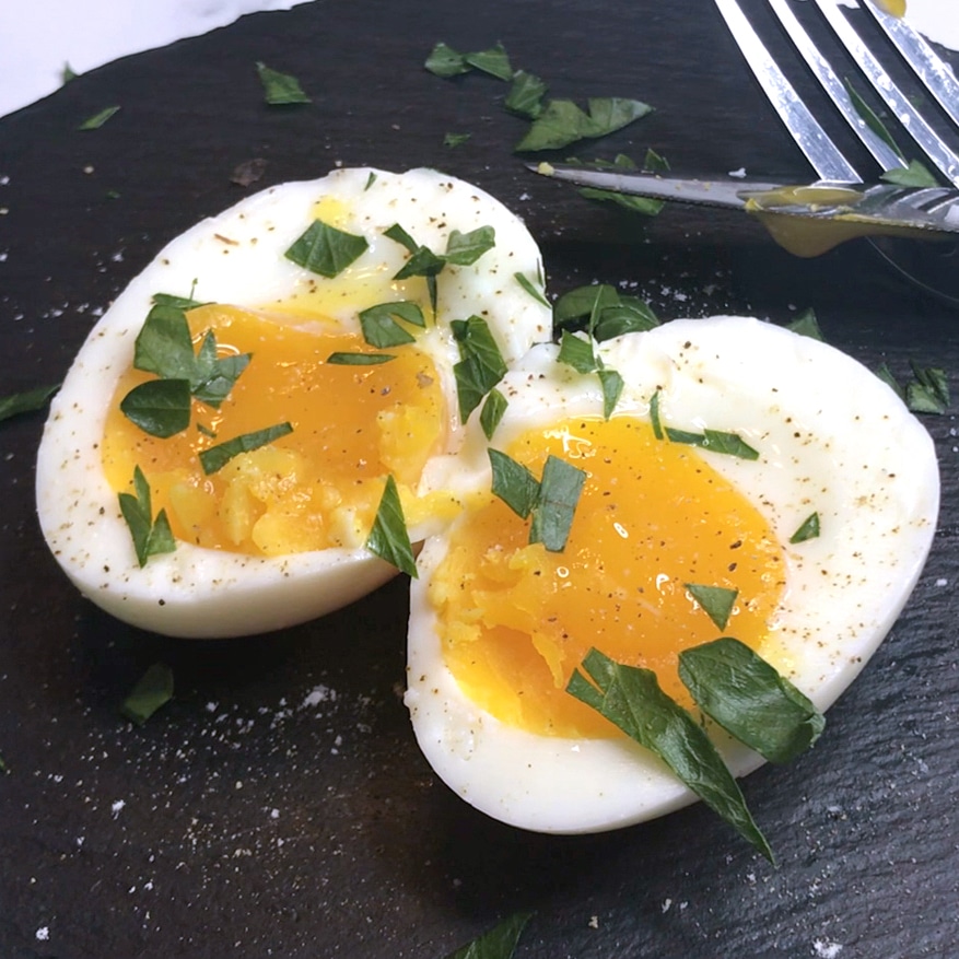 sous vide soft boiled eggs cut in half with salt and herbs