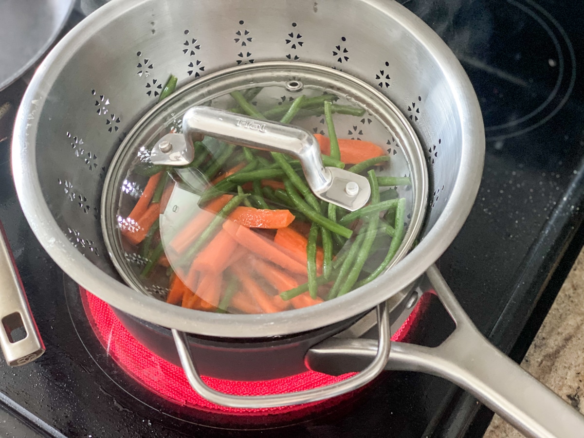 steaming carrots and greenbeans on the stove