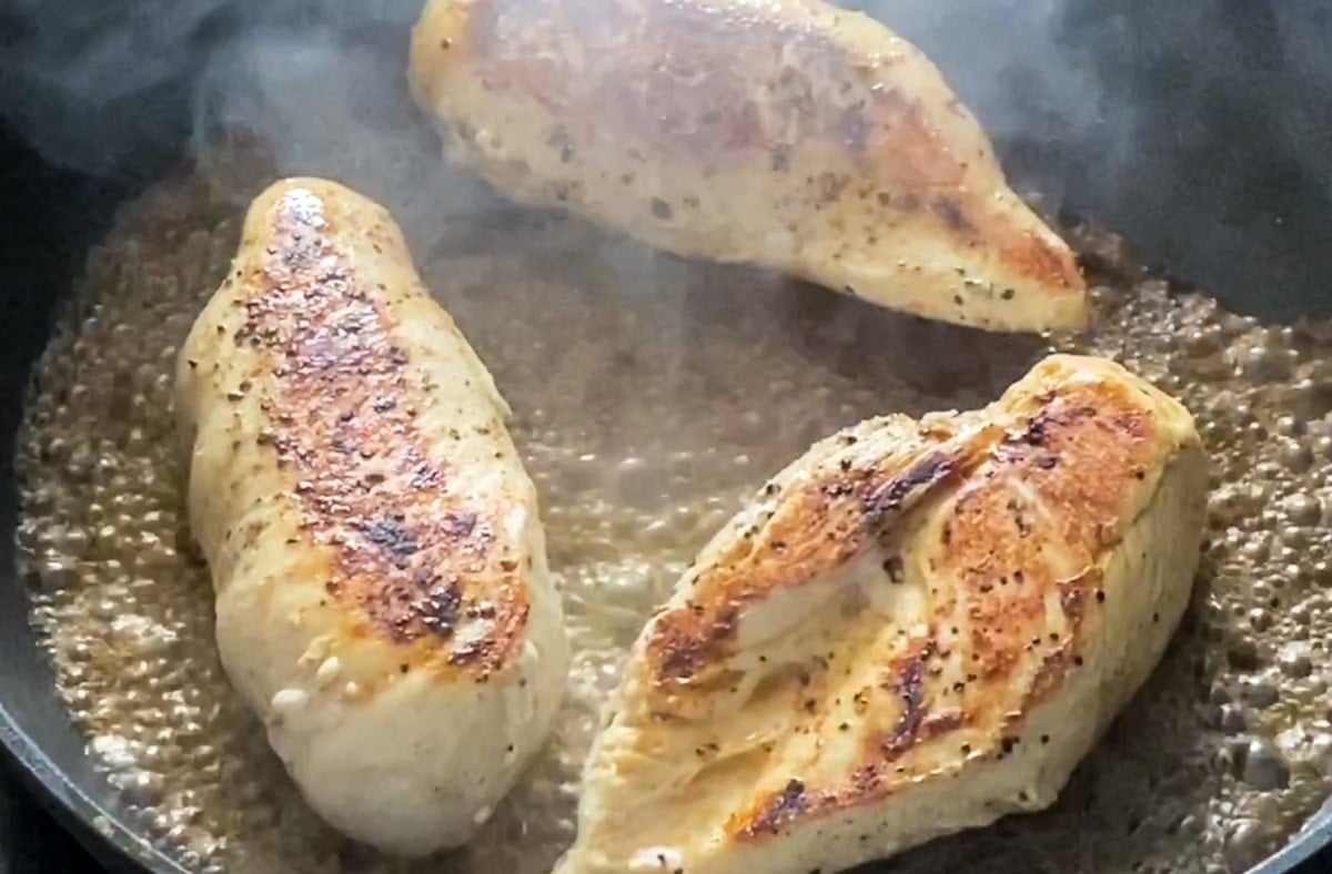 Chicken breast with water in a pan