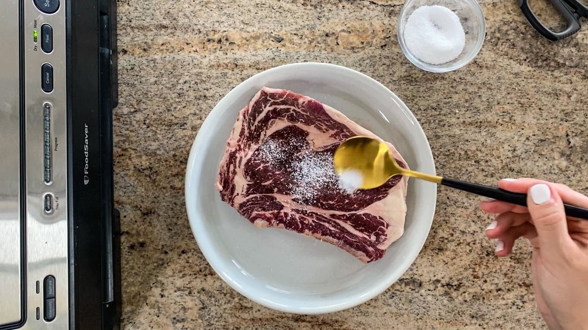 seasoning ribeye before vacuum sealing