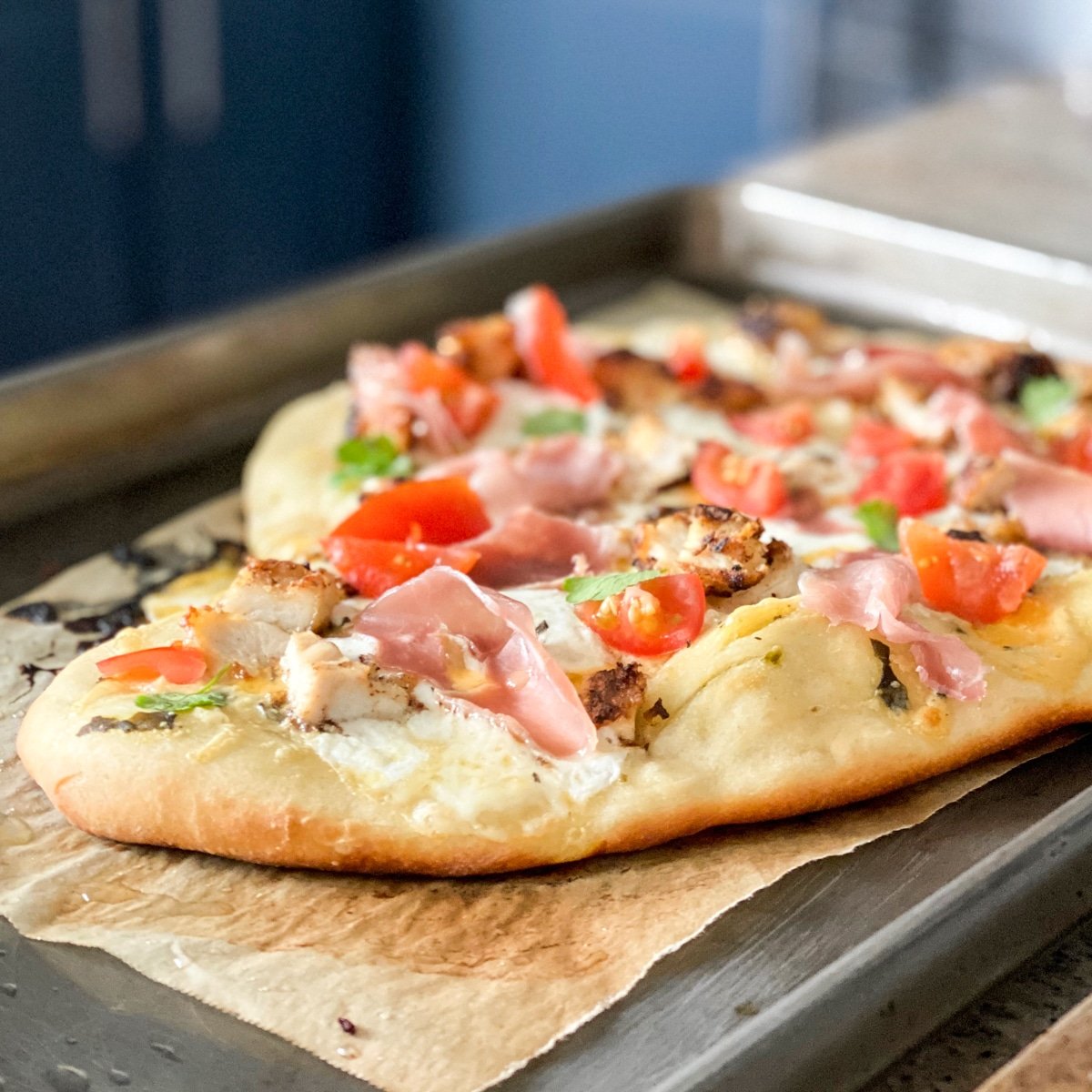 store bought pizza crust with prosciutto, mozzarrella, tomatoes