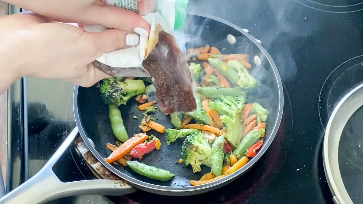 adding Birds Eye Asian sauce packet to stir fry