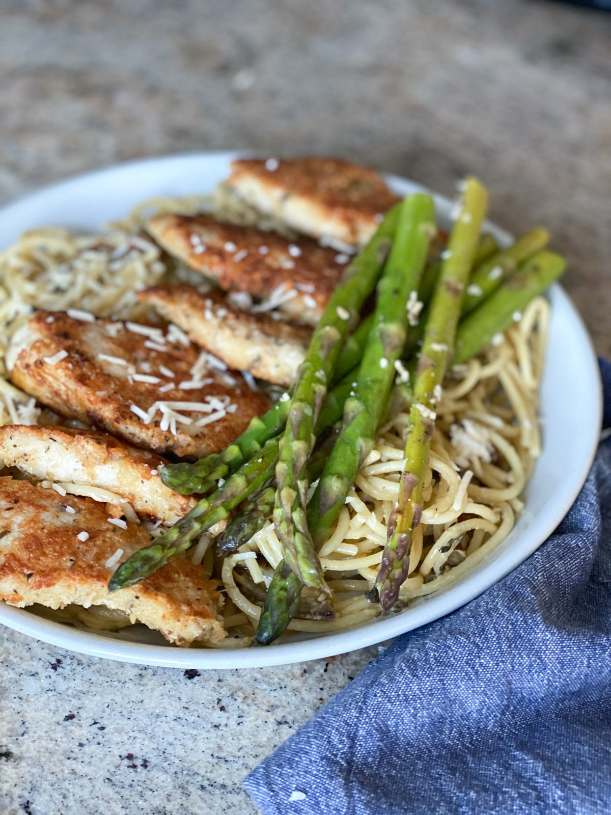 sous vide asparagus plated with chicken parmesan