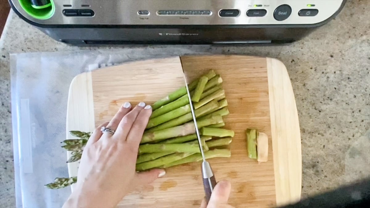 trimming asparagus before vacuum sealing it with the foodsaver 4400