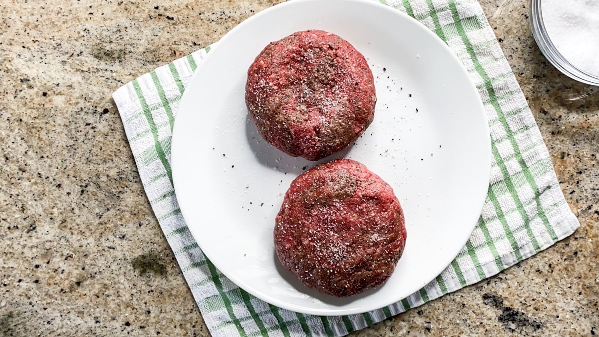 Ground beef patties seasoned on a plate