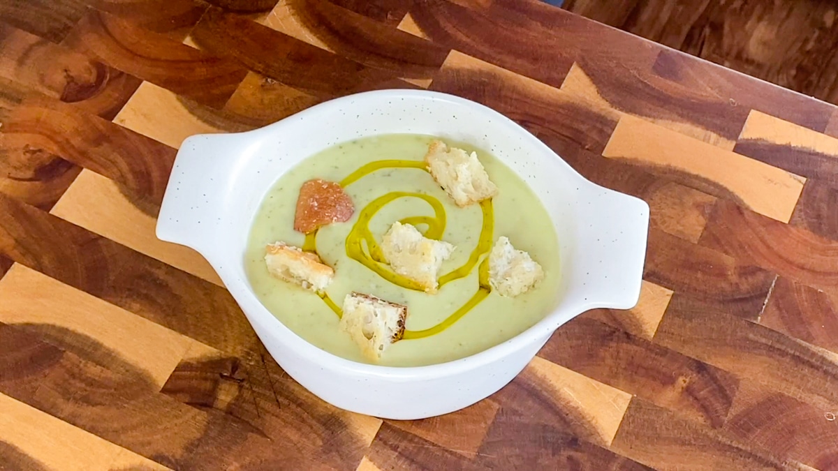 serving chilled zucchini soup with crouton toppings