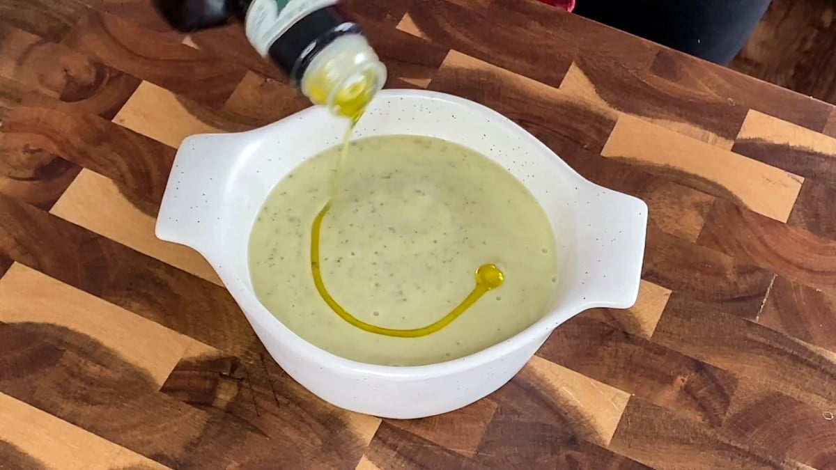 adding olive oil to chilled zucchini soup