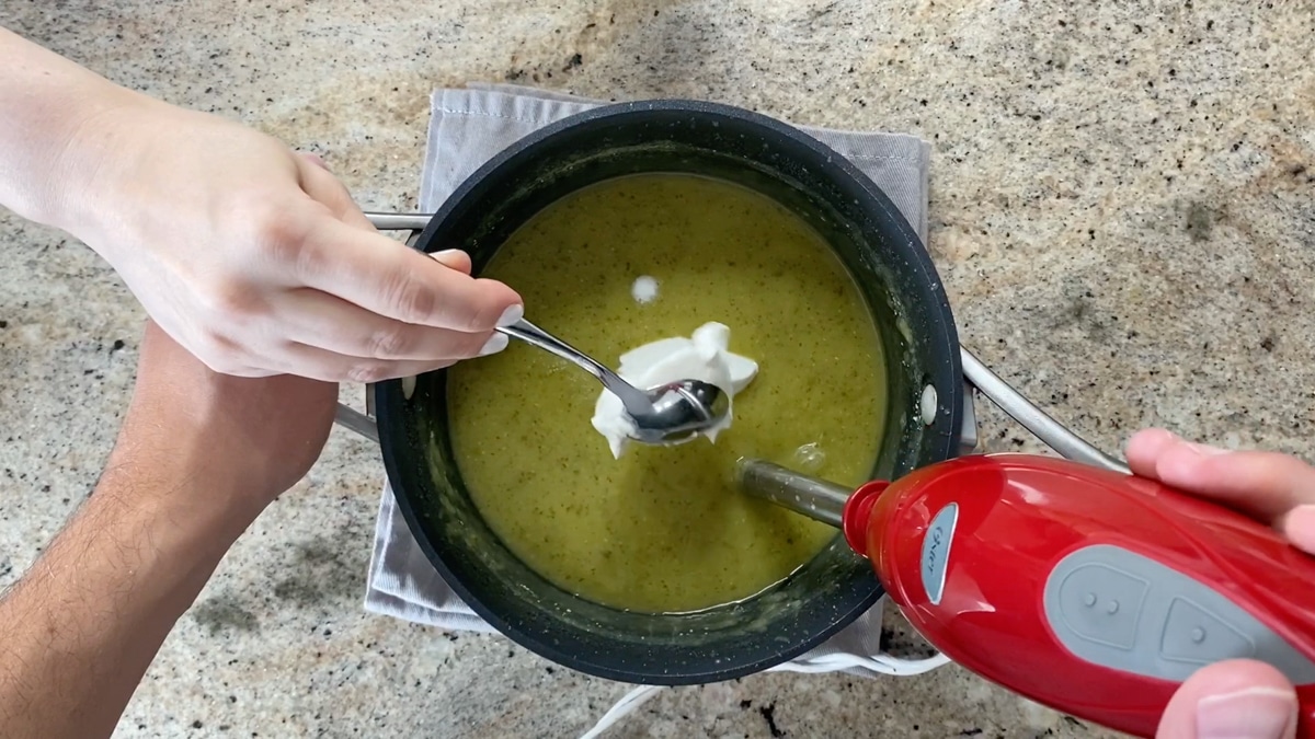 adding sour cream to zucchini soup
