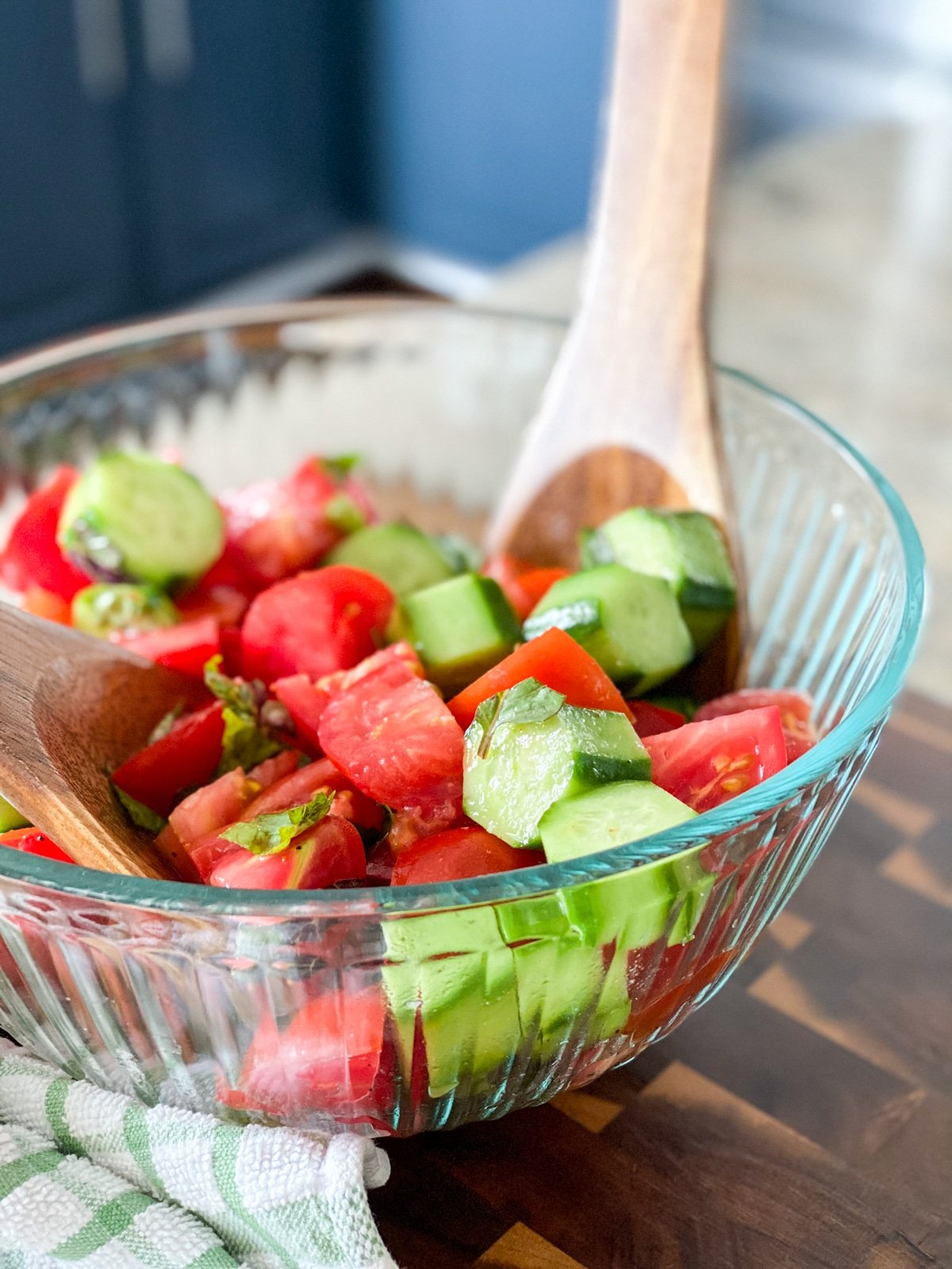 tossing the tomato cucumber salad marinated in vinegar