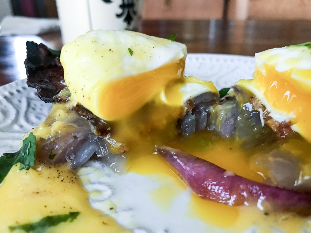 gooey sous vide poached egg with hollandaise sauce on red onion