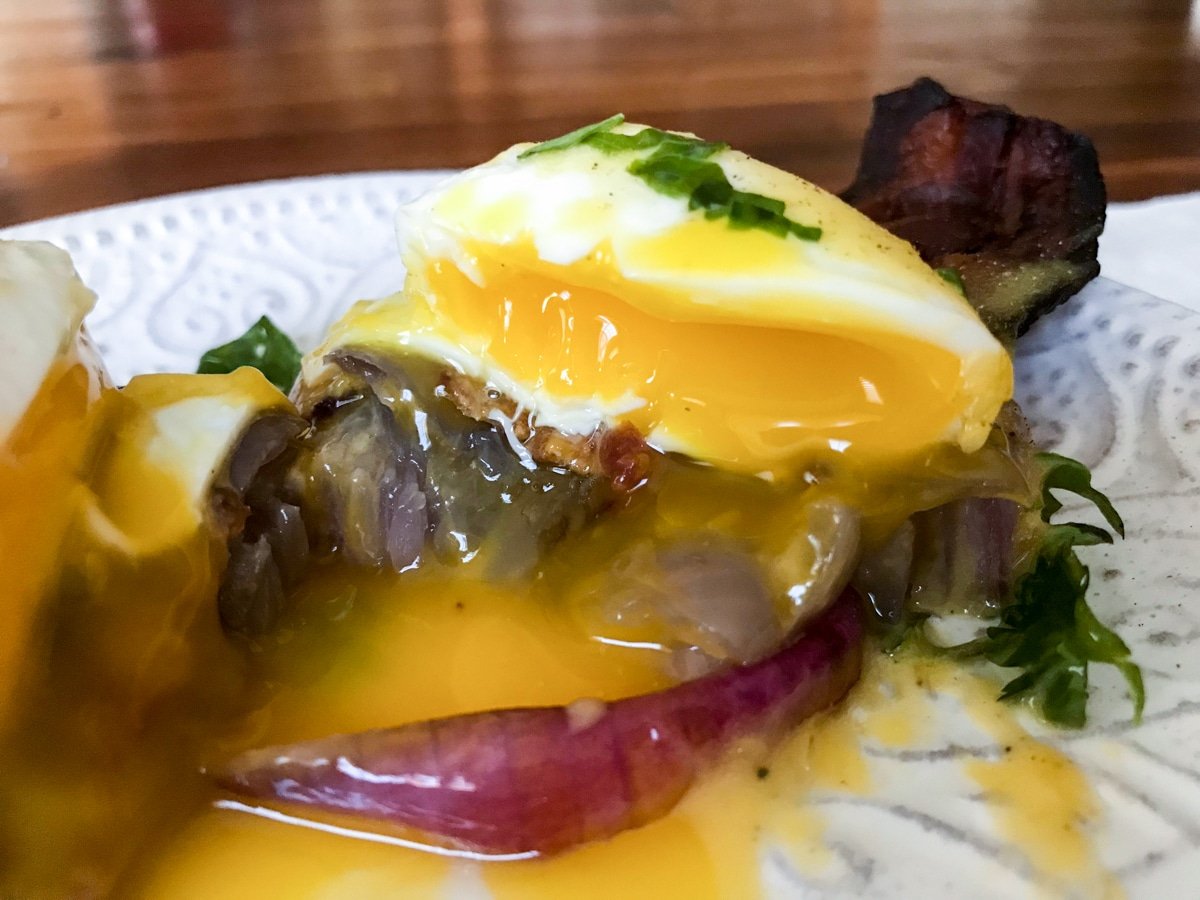 perfectly cooked sous vide poached eggs and hollandaise sauce on grilled onion