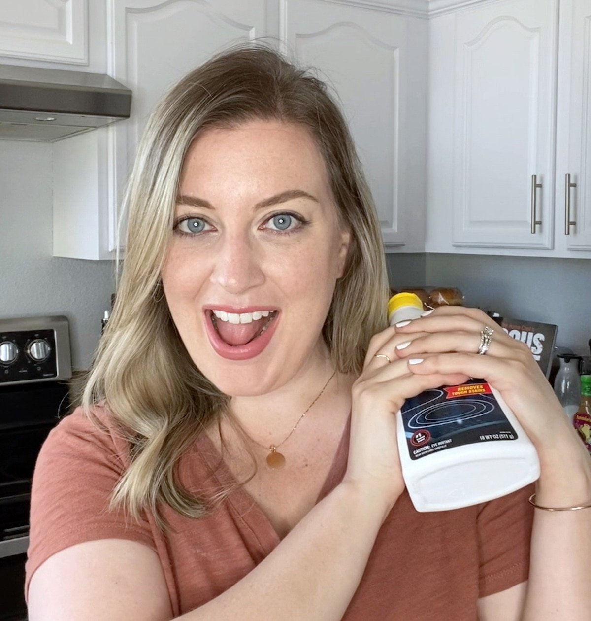 Woman posing with a stove cooktop cleaner product.