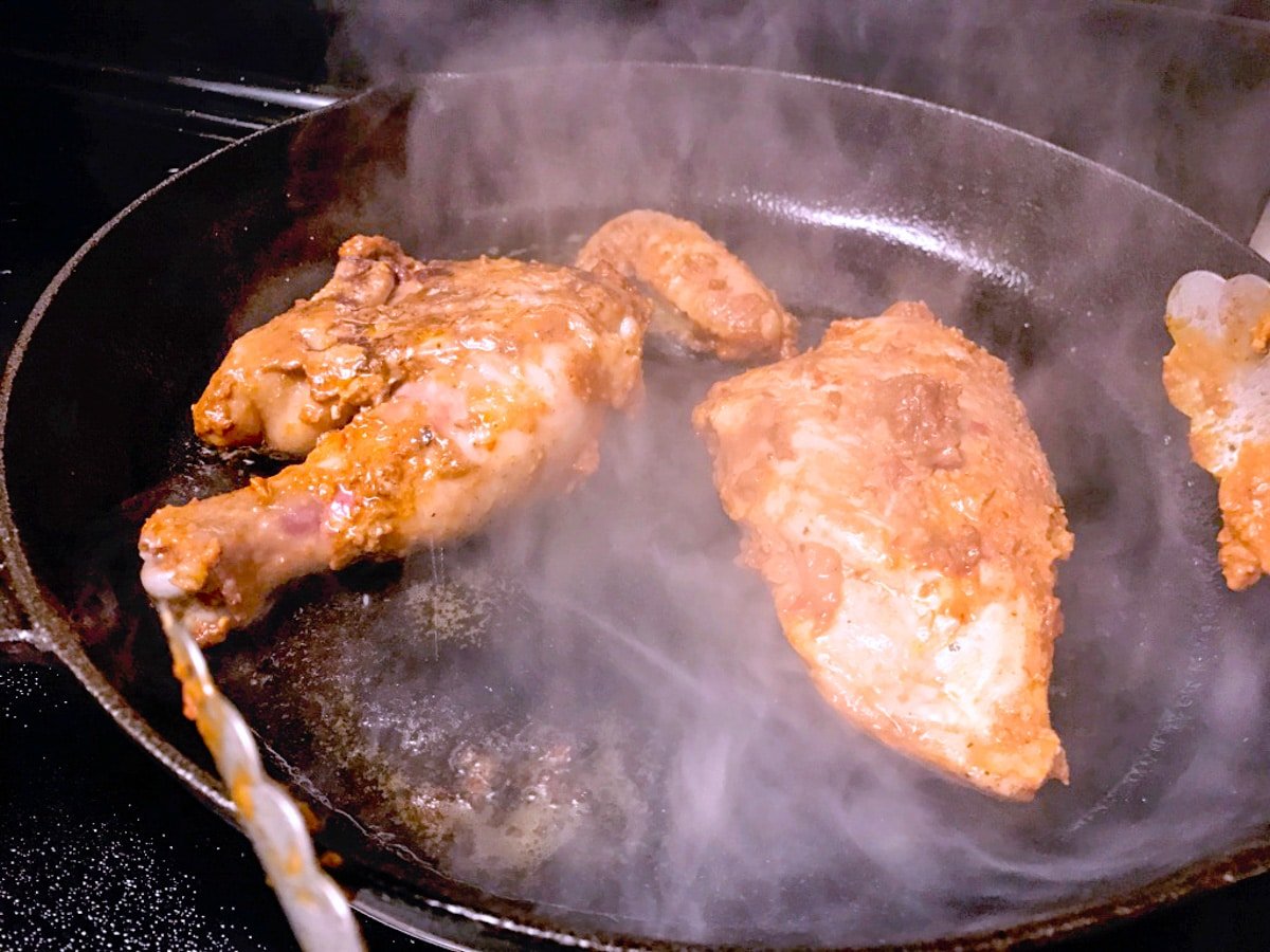 sous vide chicken legs and sous vide chicken thighs cooking in a cast iron skillet