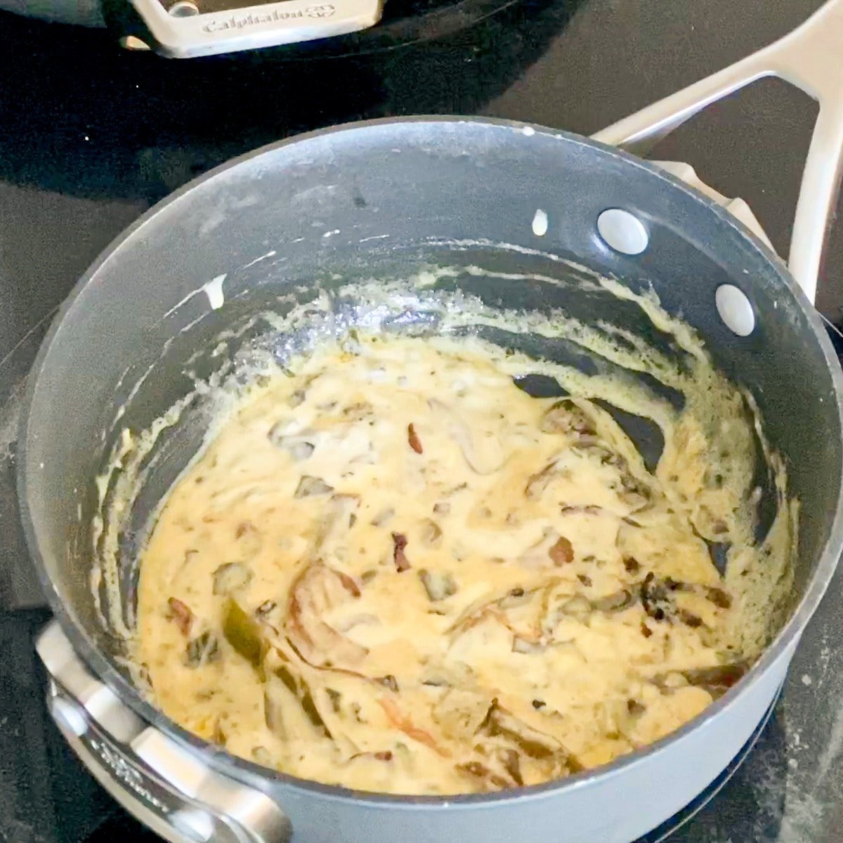 alfredo pasta sauce simmering in a sauce pan
