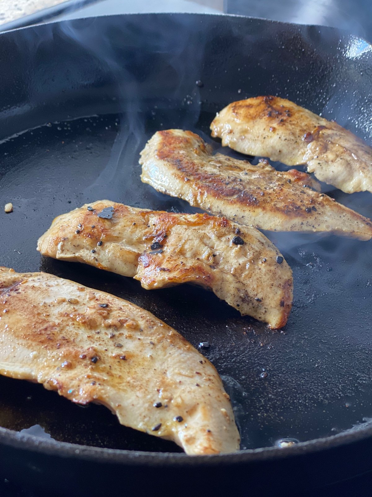 sous vide chicken breast tenders searing in a cast iron pan