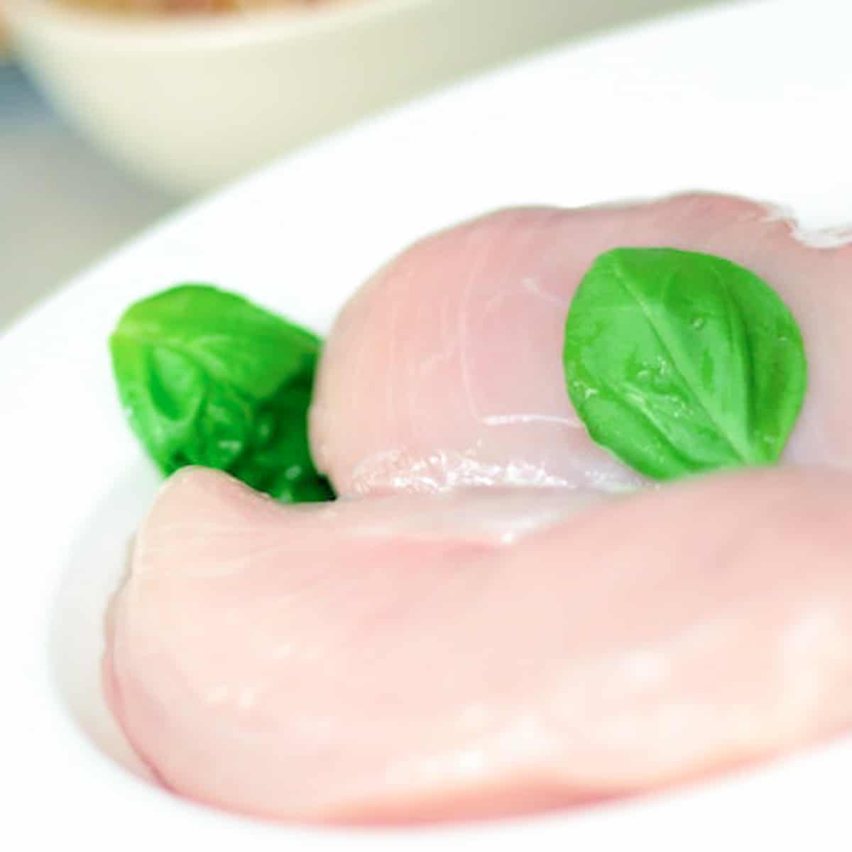 raw chicken breast with basil