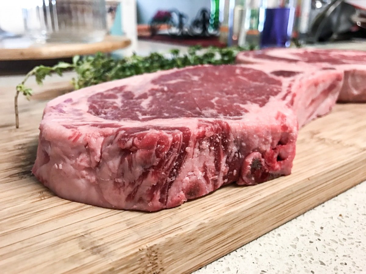 raw ribeye steak on cutting board