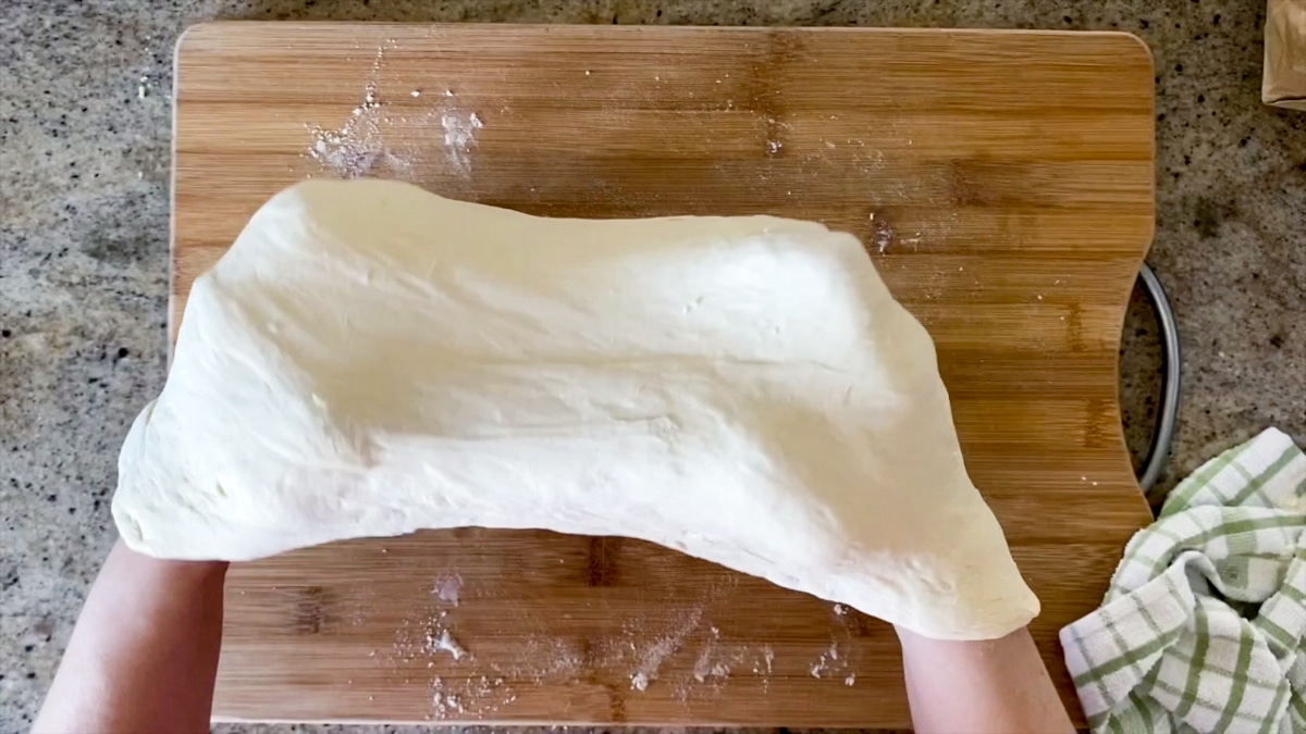 stretching pizza dough with knuckles