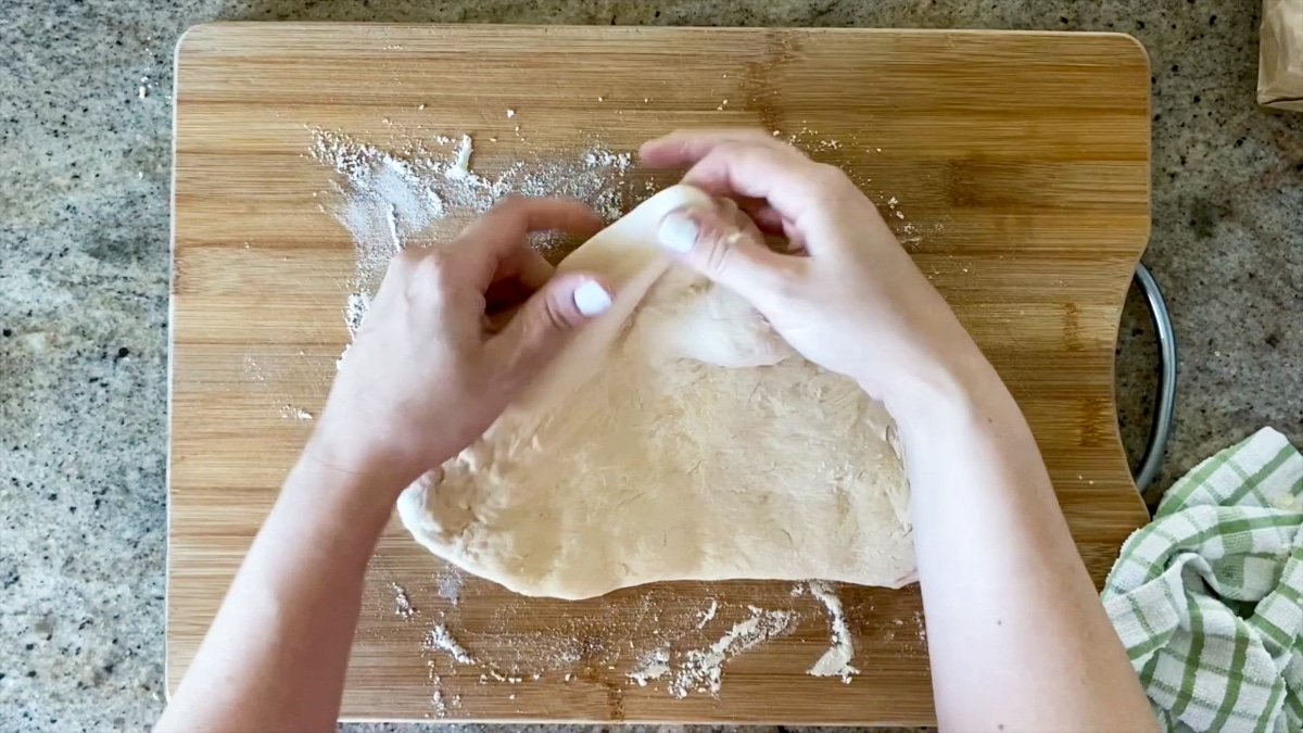 demonstrating pinching pizza dough crust