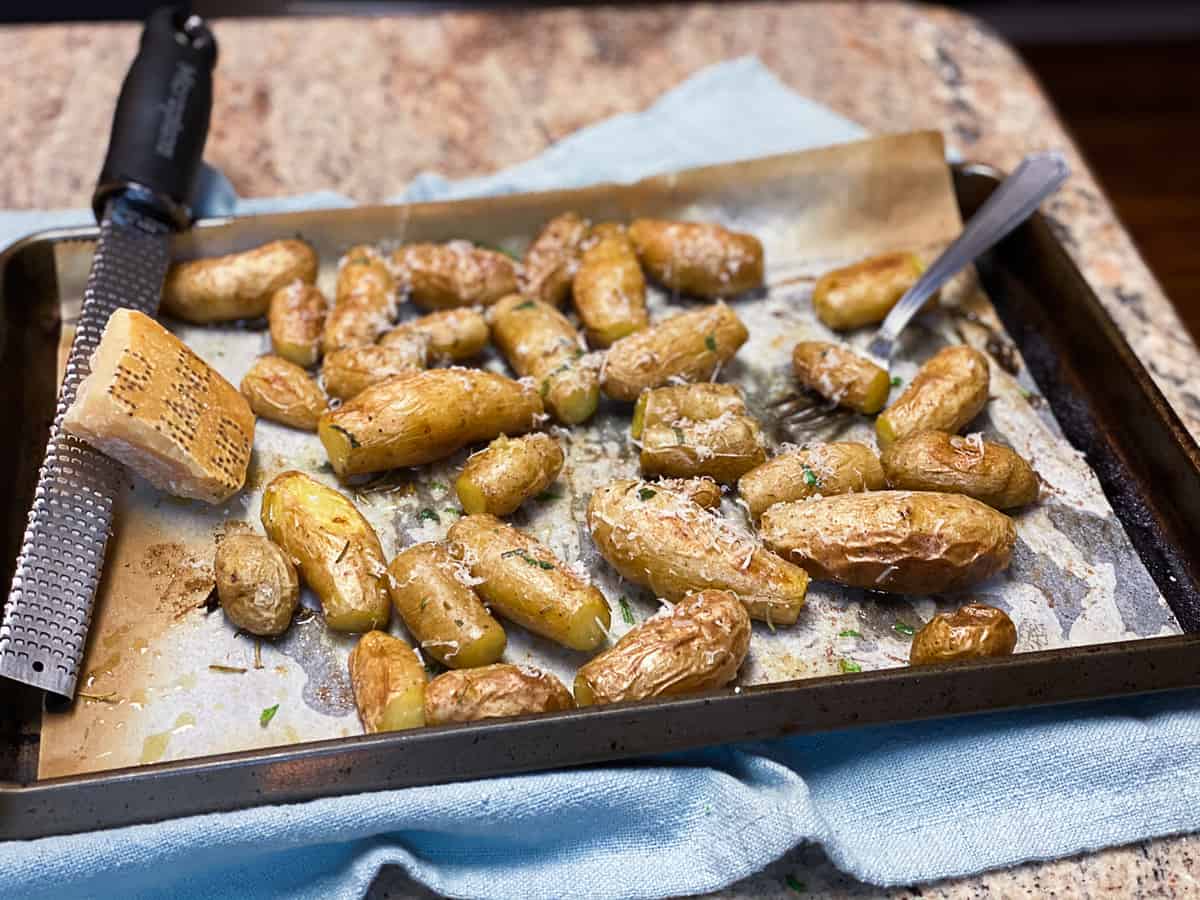top shot of small roasted potatoes on parchment paper and baking sheet