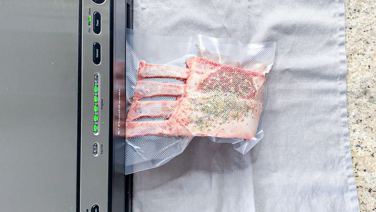 meat being vacuum sealed in plastic bag with machine