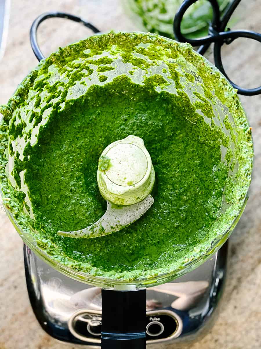 Green pesto sauce in food processor bowl